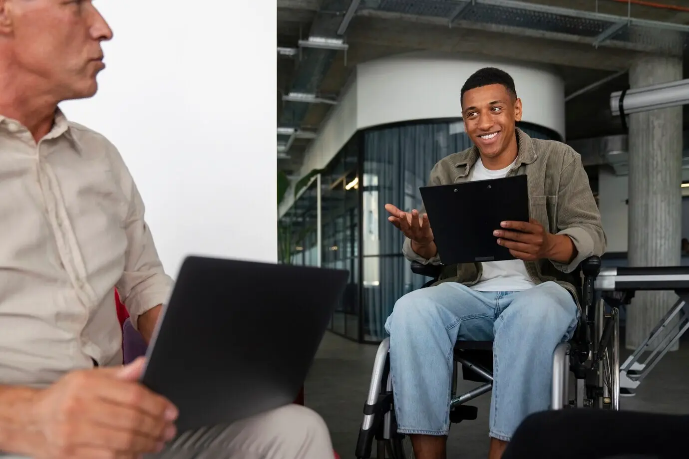 Ein Mann mit Behinderung im Rollstuhl, der einen Bürojob hat.